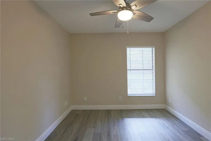Empty room featuring light wood-style floors, ceiling fan, and a textured ceiling
