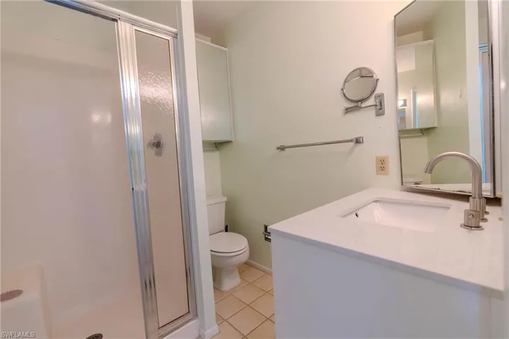 Bathroom with a stall shower, vanity, and light tile patterned floors