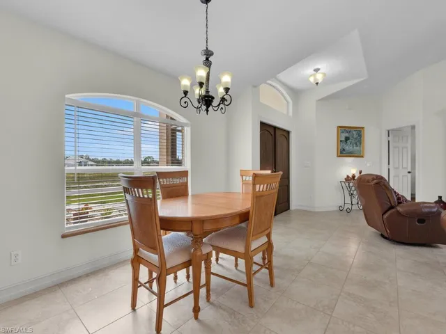 Dining room with a chandelier, baseboards, and light tile patterned floors