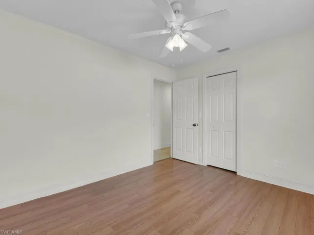 Unfurnished bedroom featuring light wood finished floors, baseboards, a closet, and a ceiling fan