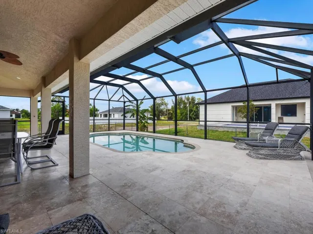 Outdoor pool with ceiling fan, a patio, and glass enclosure
