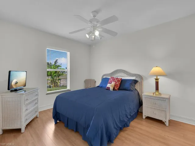 Bedroom featuring light wood-style floors, baseboards, and ceiling fan
