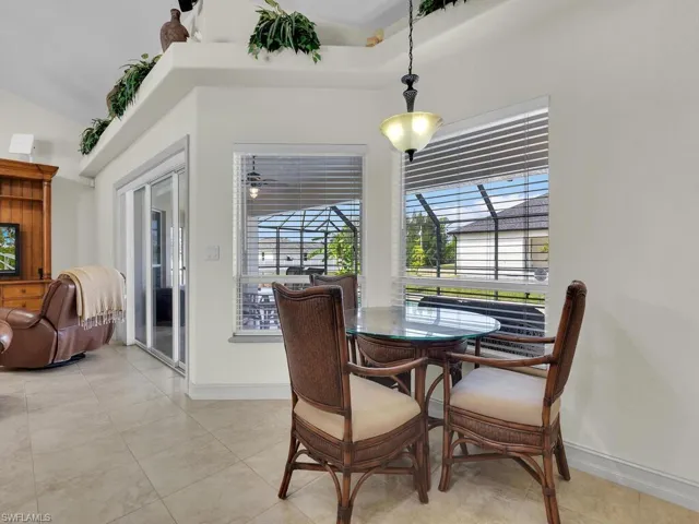 Dining space with vaulted ceiling, baseboards, a sunroom, and light tile patterned flooring