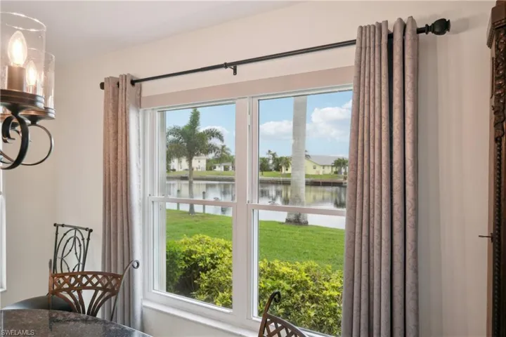 Doorway to outside with a water view and a notable chandelier