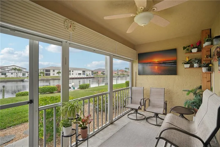 Sunroom featuring a water view and ceiling fan