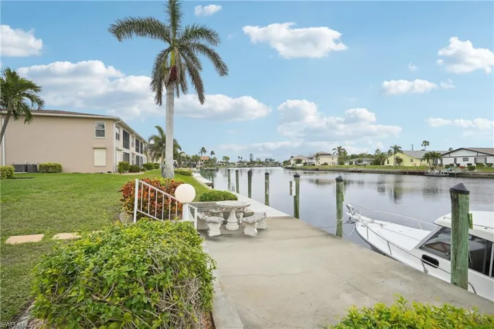 View of dock featuring a yard and a water view