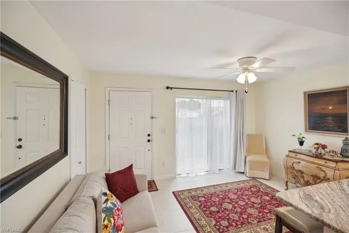 Living room with ceiling fan and light tile patterned floors