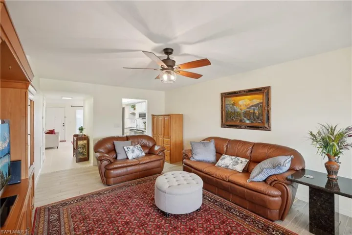 Living room with light hardwood / wood-style floors and ceiling fan