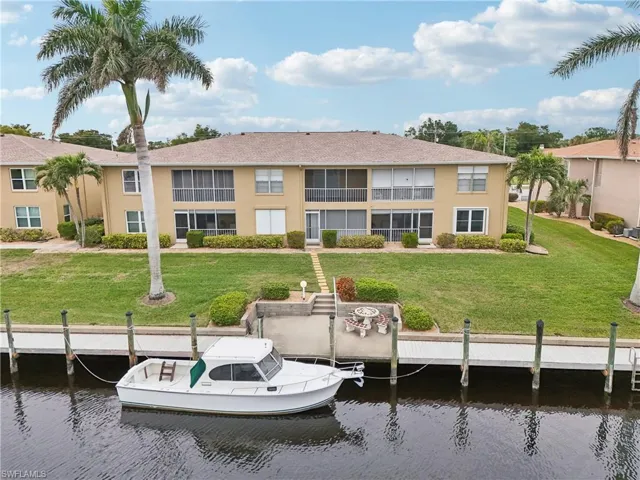 View of dock with a water view and a lawn