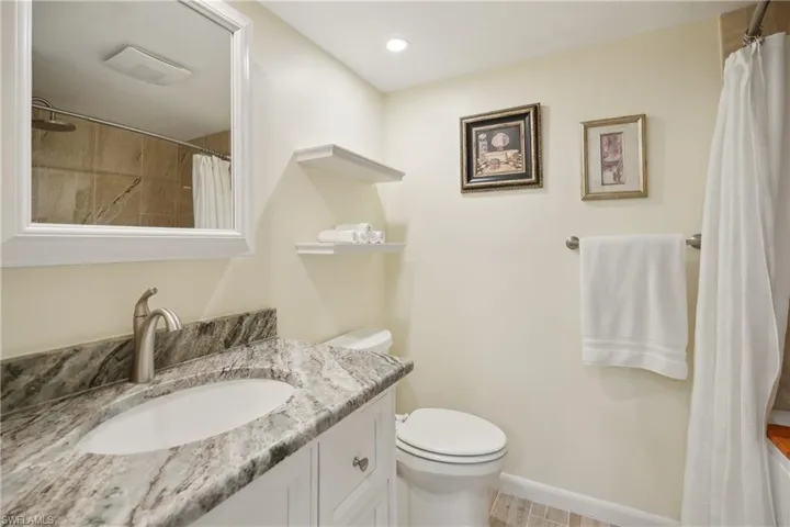 Bathroom featuring vanity, toilet, and walk in shower