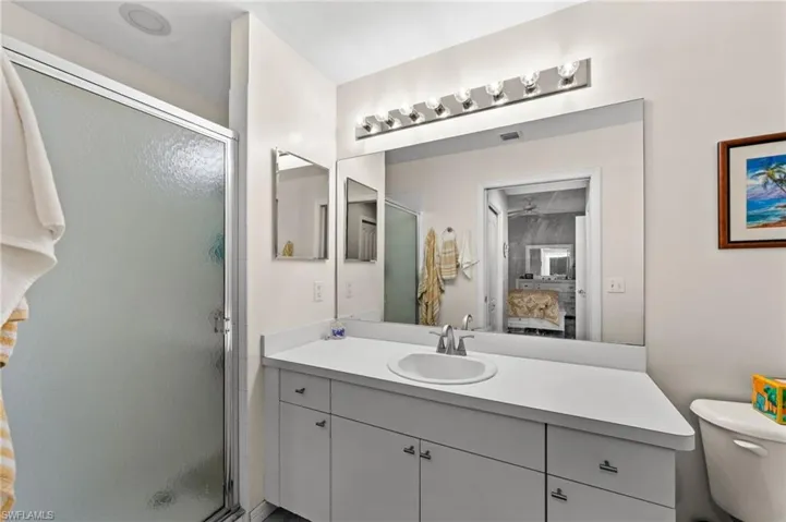 Bathroom featuring a white vanity with integrated sink, chrome-finish faucet, and a large wall-mounted mirror