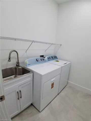 Washroom with washing machine and clothes dryer and cabinet space
