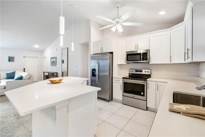 Pearl Quartz Countertops with White Shaker Cabinets and Stainless Appliances