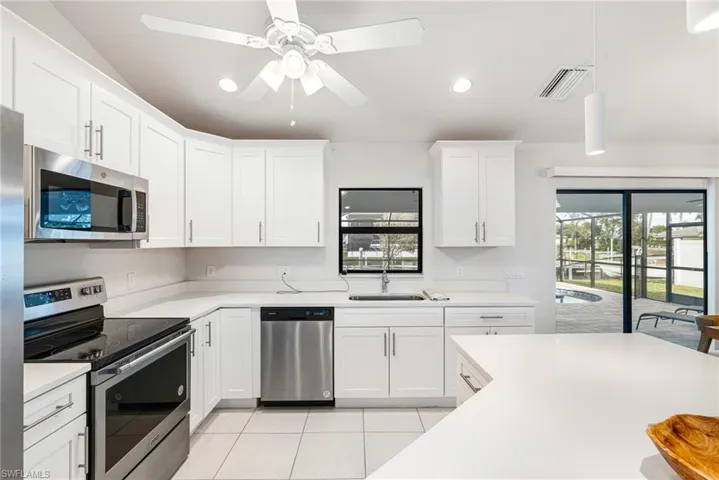 Pearl Quartz Countertops with White Shaker Cabinets and Stainless Appliances