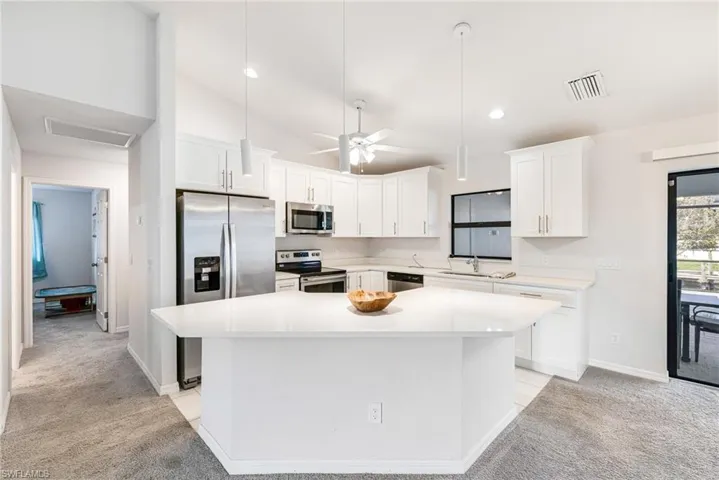 Pearl Quartz Countertops with White Shaker Cabinets and Stainless Appliances
