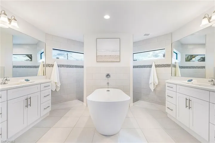 with a Spa like feel this Primary Bath host modern soak tub, dueling vanities & Party shower!