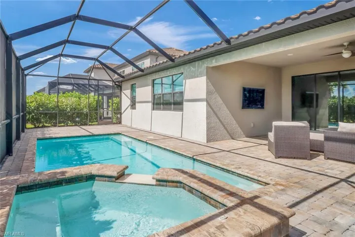 View of pool featuring a patio, a lanai, an in ground hot tub, and ceiling fan