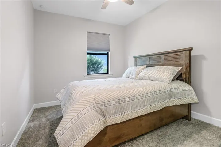 Carpeted bedroom featuring ceiling fan