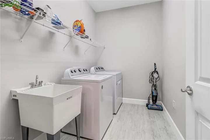 Laundry area featuring sink, light hardwood / wood-style floors, and separate washer and dryer