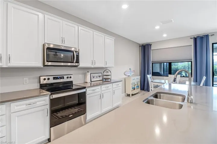 Kitchen featuring white cabinetry, sink, and stainless steel appliances