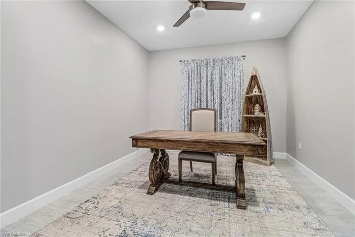 Office area with ceiling fan and wood-type flooring