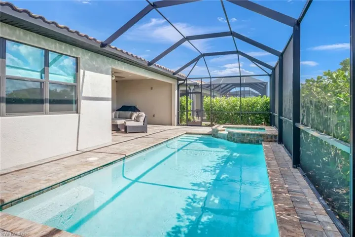 View of pool with an outdoor living space, a lanai, an in ground hot tub, and a patio