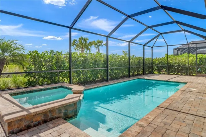 View of pool with a lanai, an in ground hot tub, and a patio area