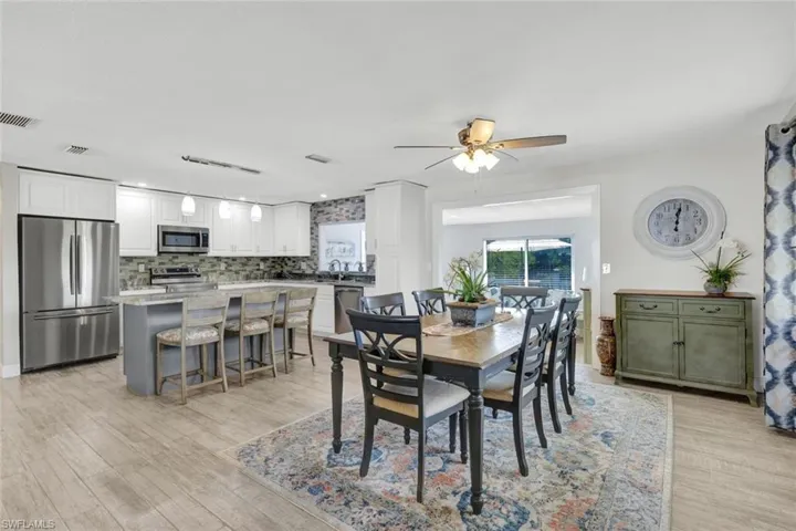 Dining space with ceiling fan and light wood-style flooring