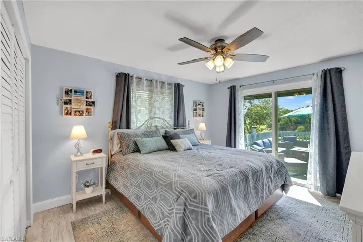 Bedroom featuring access to exterior, multiple windows, light wood-style flooring, and ceiling fan