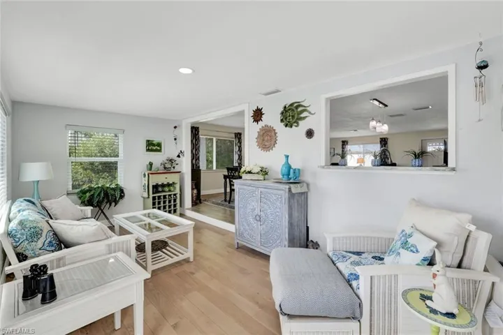 Living area with light wood finished floors, healthy amount of natural light, and recessed lighting