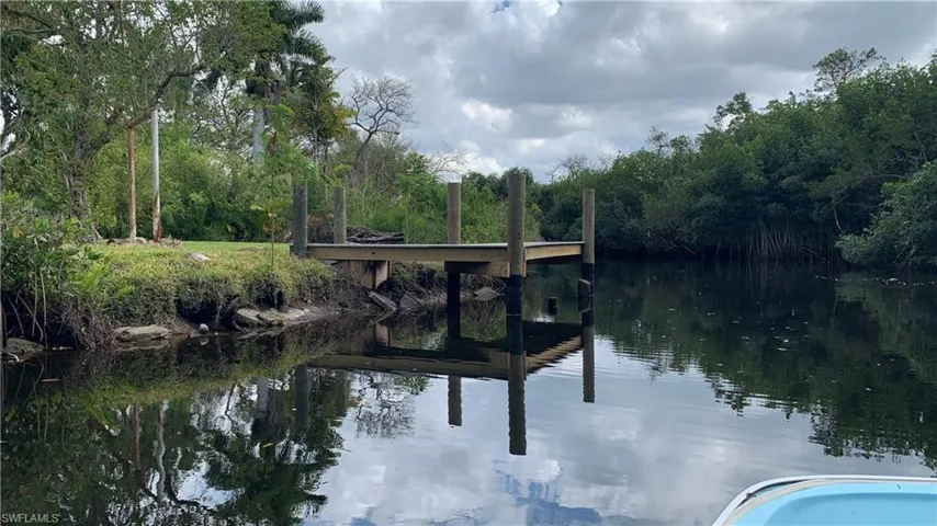 Dock area featuring a water view and a wooded view