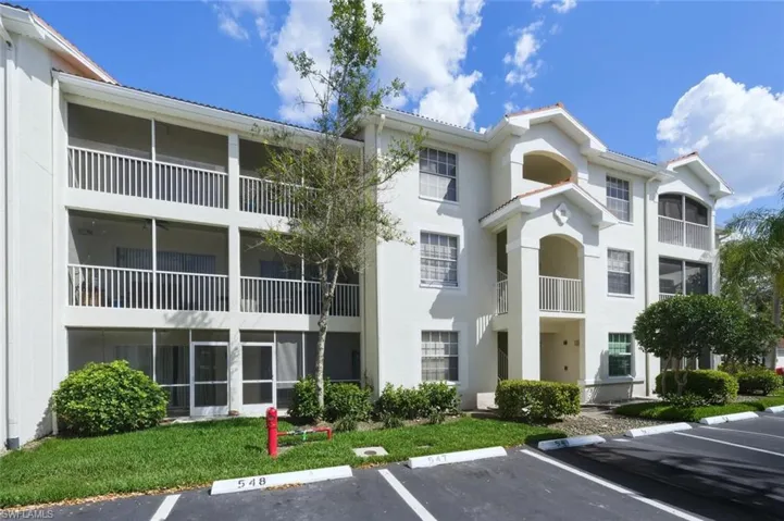 View of apartment building / complex featuring uncovered parking