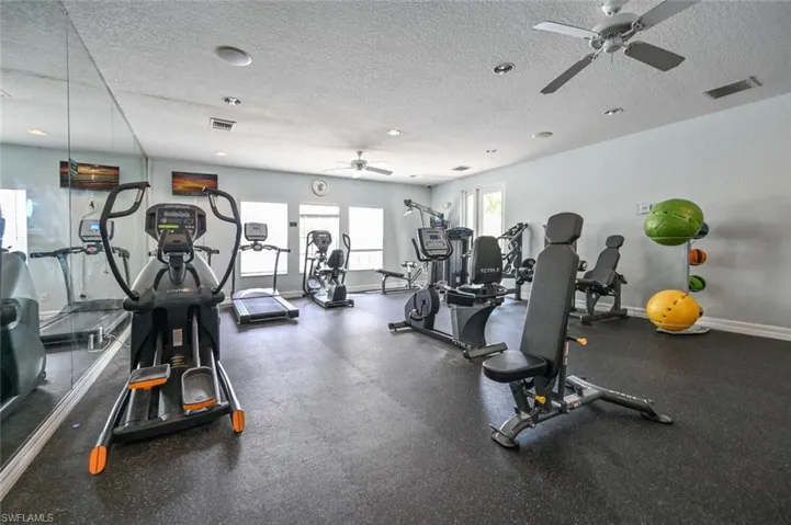 Gym featuring ceiling fan and a textured ceiling