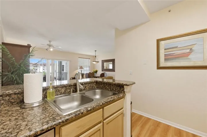 Kitchen featuring light wood finish cabinets, pendant lighting, ceiling fan, and light wood finished floors