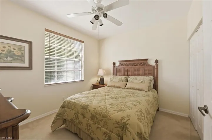 Bedroom featuring a closet, a ceiling fan, and light carpet