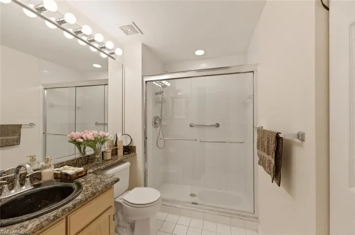 Full bath with vanity, a stall shower, and light tile patterned floors