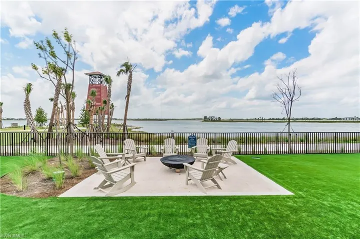 View of patio with an outdoor fire pit and a water view