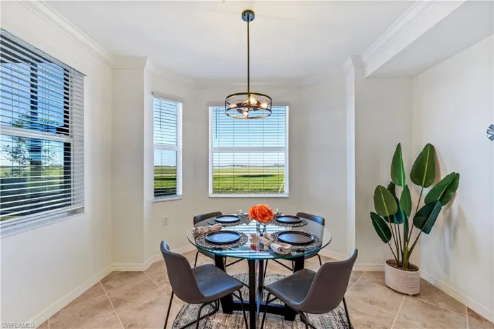 Dining room with crown molding, a chandelier, and light tile floors