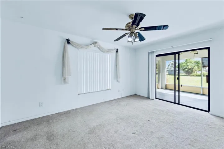 Unfurnished room with ceiling fan and light colored carpet