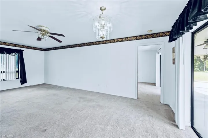 Carpeted spare room featuring ceiling fan
