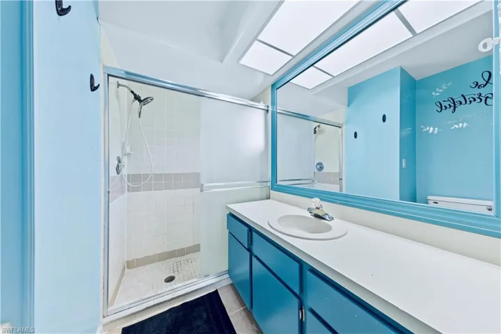 Bathroom featuring tile patterned floors, vanity, toilet, and a shower with shower door