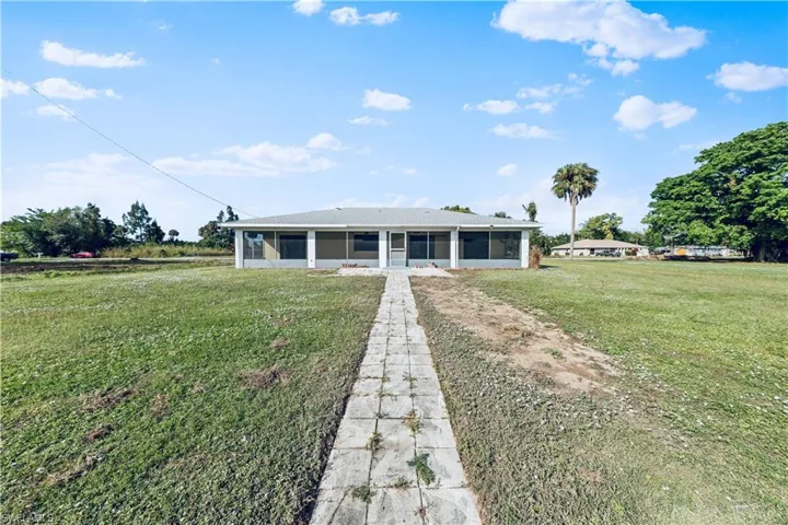 View of front of property featuring a sunroom and a front yard