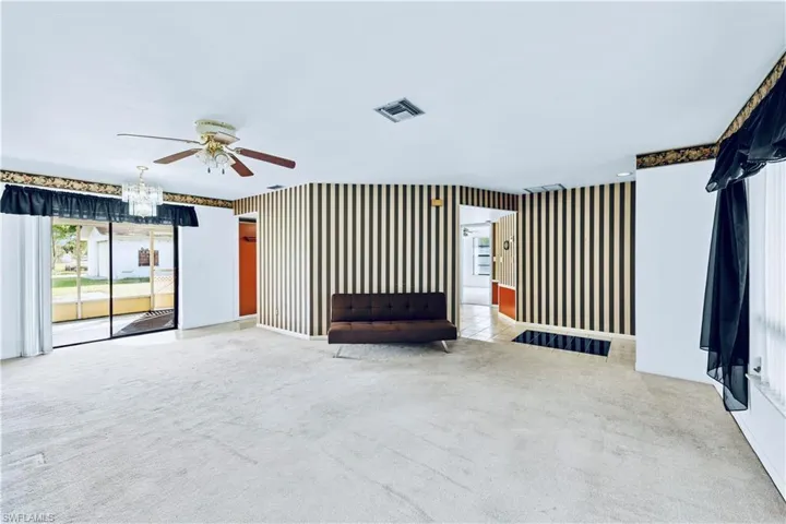 Unfurnished living room with carpet floors and ceiling fan