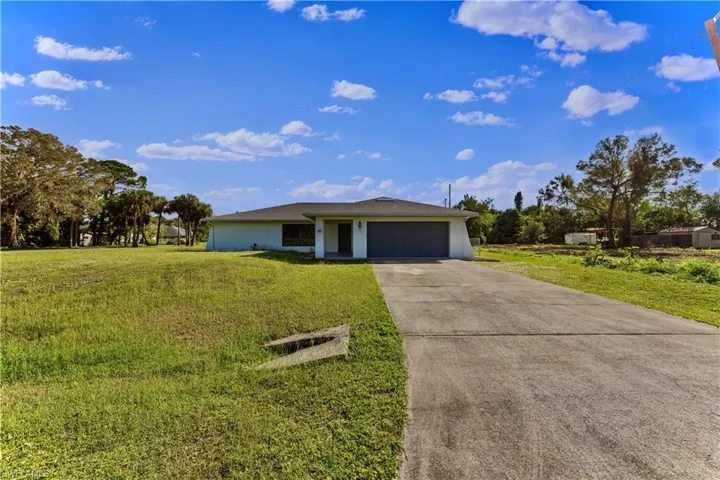 Single story home with a front yard and a garage