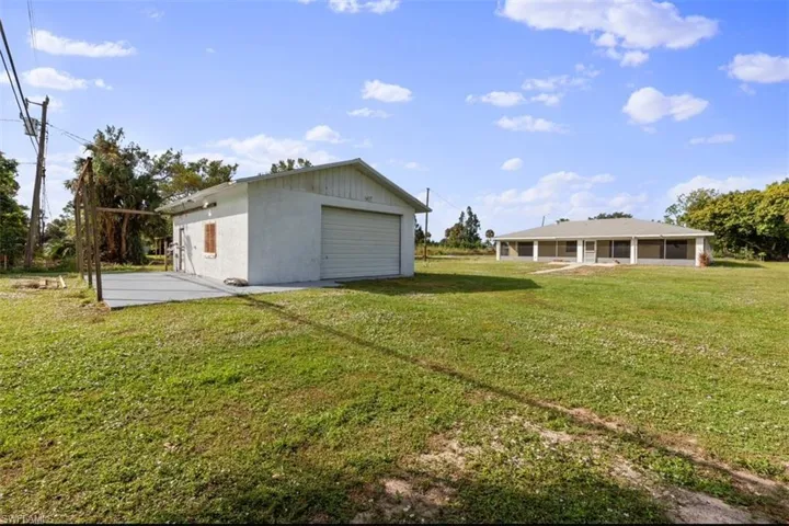 View of yard featuring a garage and an outbuilding