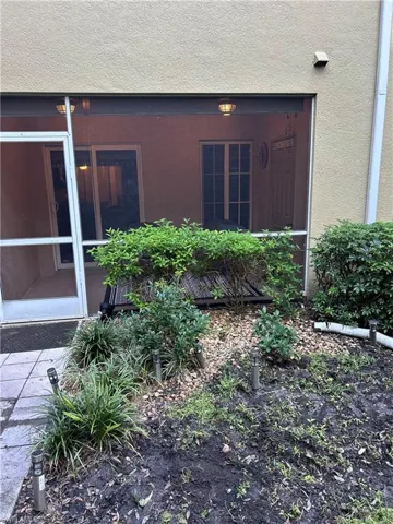 Doorway to property featuring stucco siding and patio