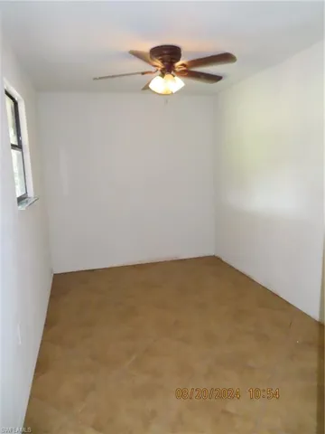 Unfurnished room with light tile patterned floors and ceiling fan