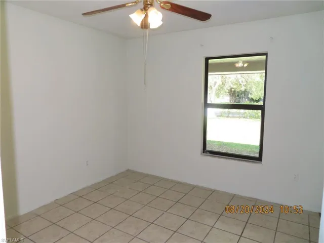Spare room with ceiling fan, a healthy amount of sunlight, and light tile patterned floors