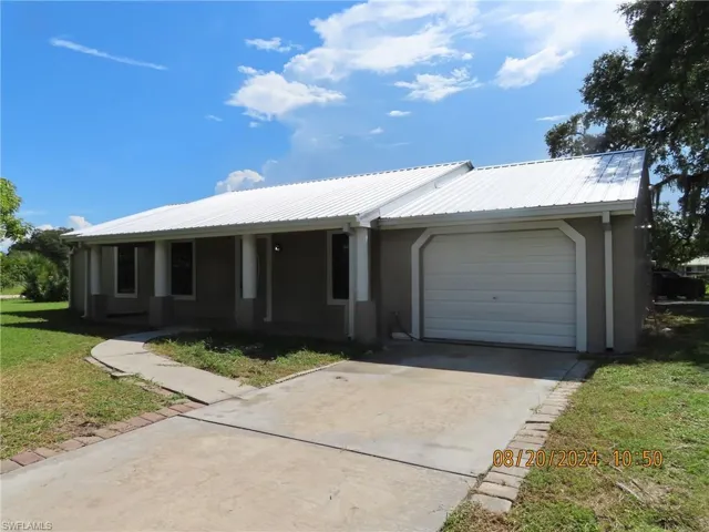 Single story home featuring a front lawn and a garage
