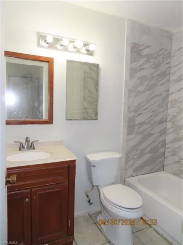 Full bathroom featuring tile patterned flooring, toilet, tiled shower / bath, and vanity